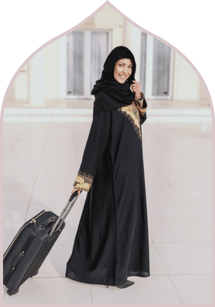 muslim woman in black abaya with suitcase